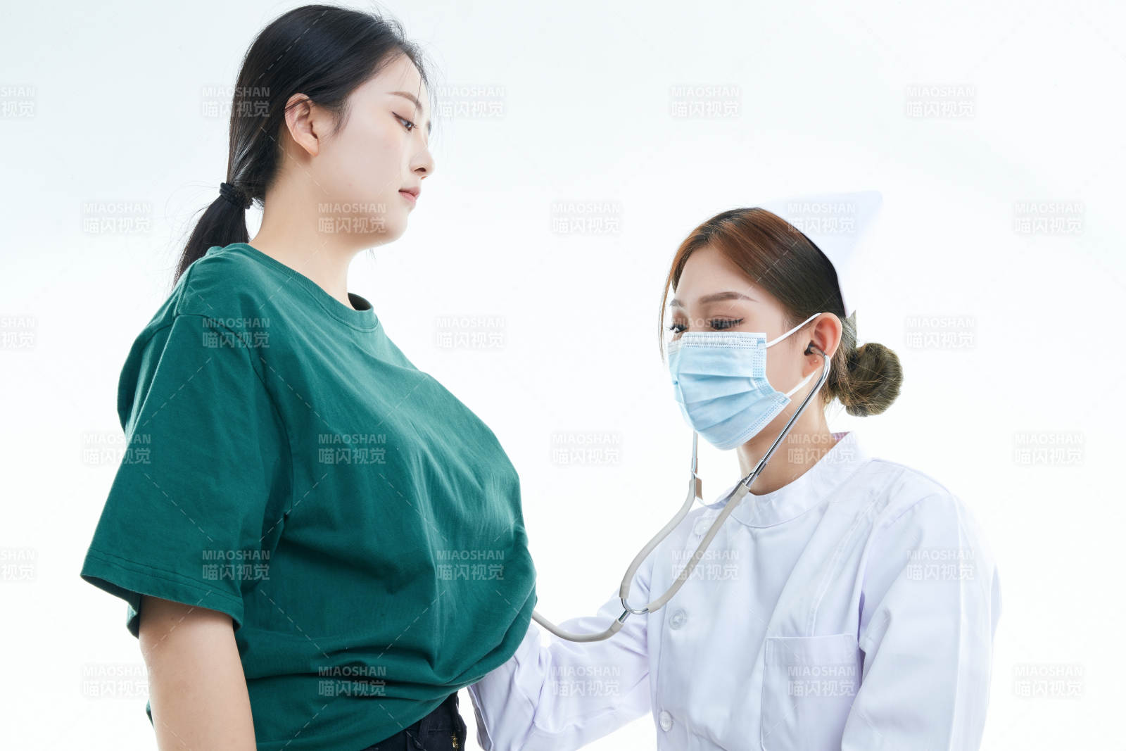 佩戴听诊器的女性医护人员为患者听诊检查图片