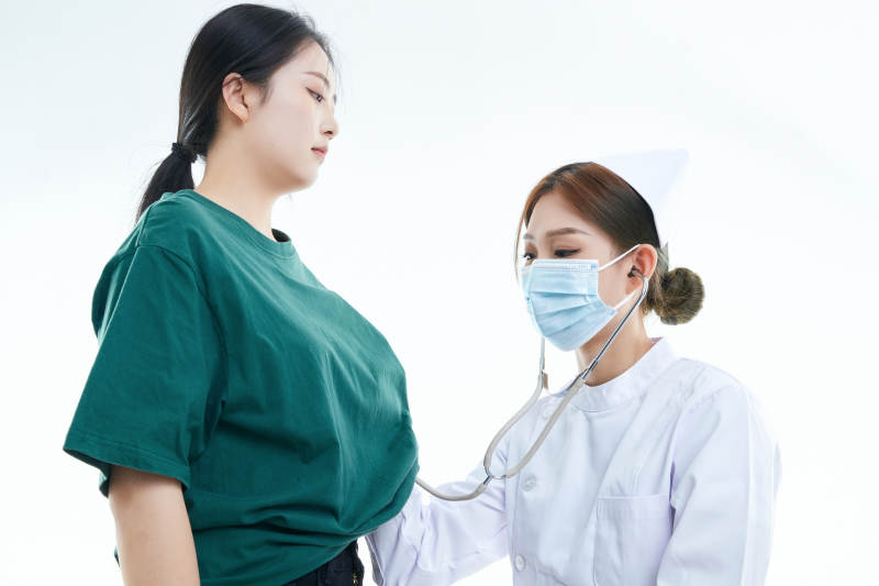 佩戴听诊器的女性医护人员为患者听诊检查图片