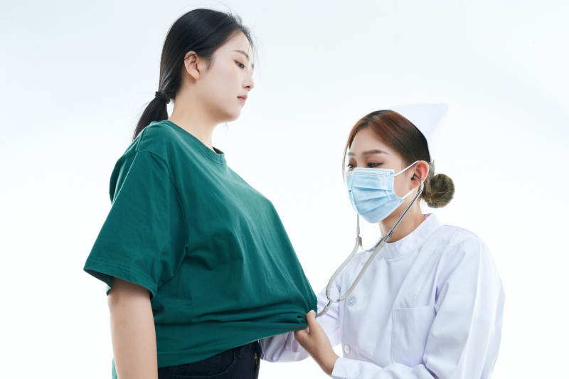 佩戴听诊器的女性医护人员为患者听诊检查图片