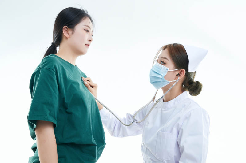 佩戴听诊器的女性医护人员为患者听诊检查图片