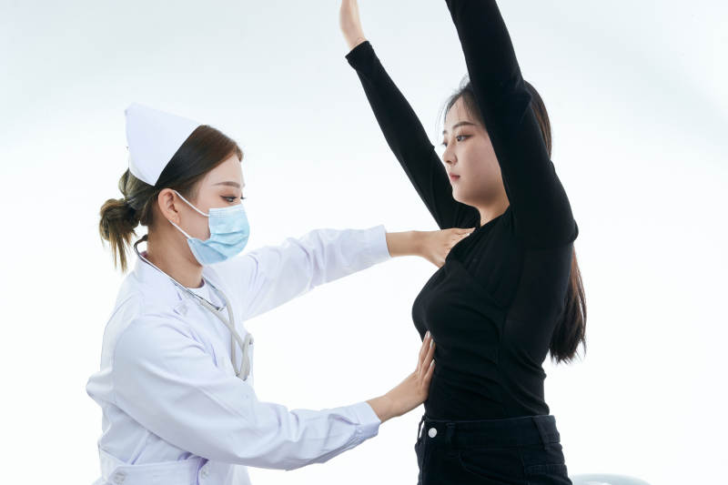 年轻的女性医护人员为患者进行胸部检查图片