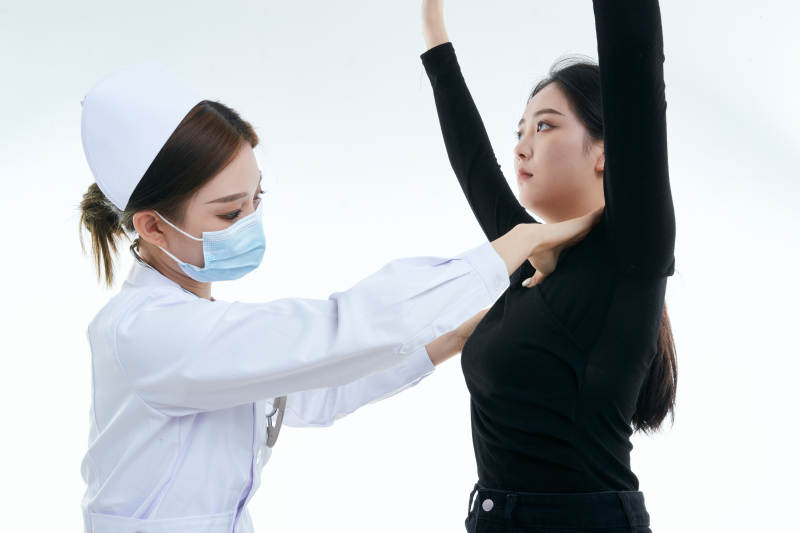 年轻的女性医护人员为患者进行胸部检查图片