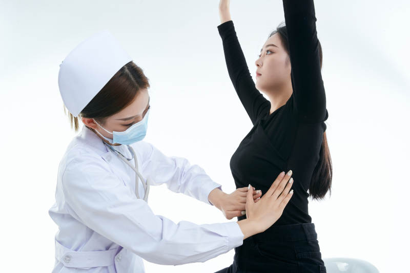 年轻的女性医护人员为患者进行胸部检查图片