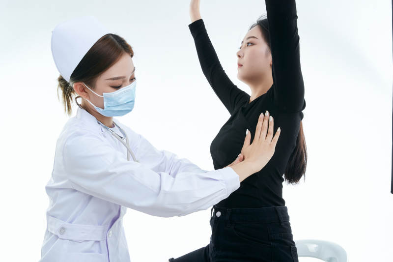 年轻的女性医护人员为患者进行胸部检查图片