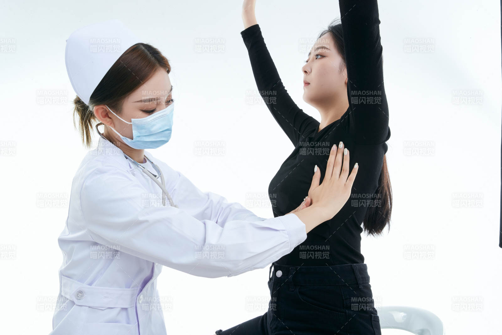 年轻的女性医护人员为患者进行胸部检查图片