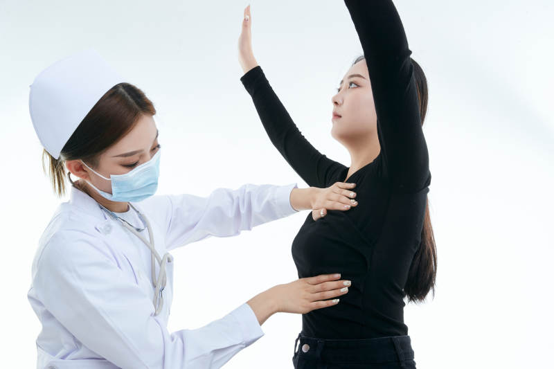 年轻的女性医护人员为患者进行胸部检查图片