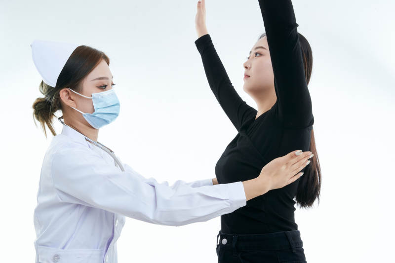 年轻的女性医护人员为患者进行胸部检查图片