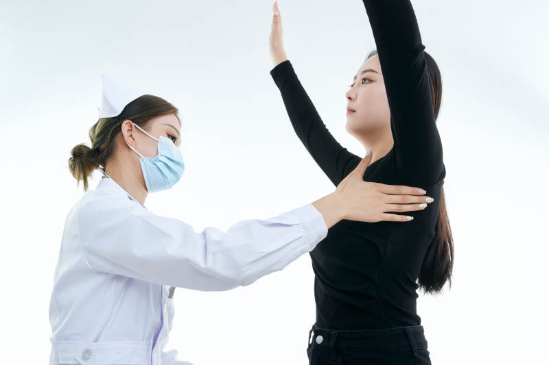 年轻的女性医护人员为患者进行胸部检查图片