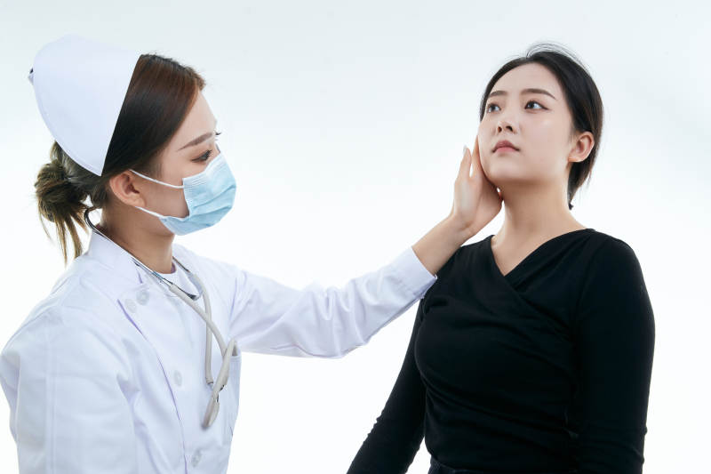 年轻的女性医护人员为患者进行胸部检查图片