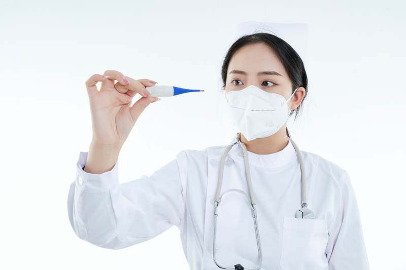 手持温度计的白衣女性医护人员图片