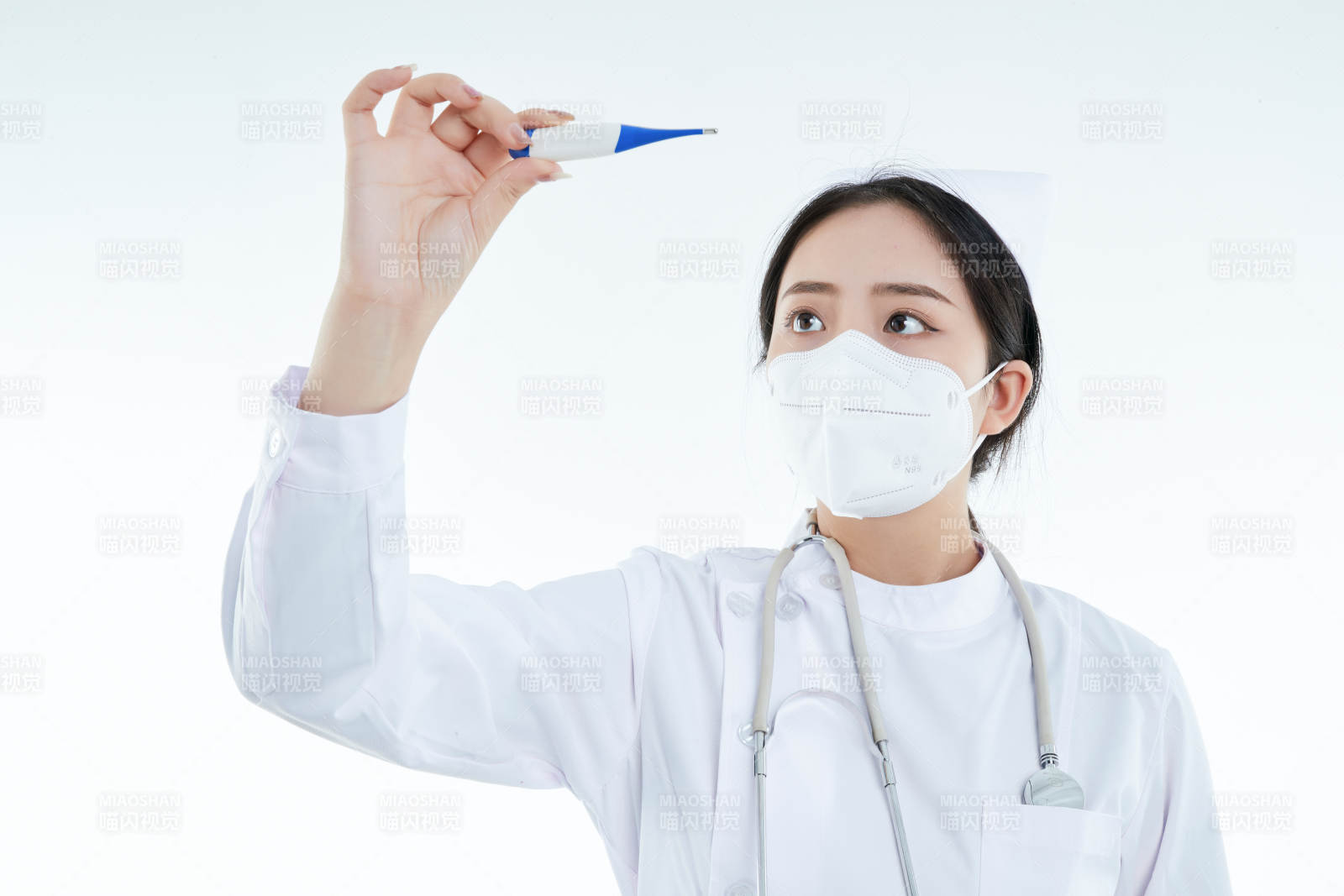 手持温度计的白衣女性医护人员图片
