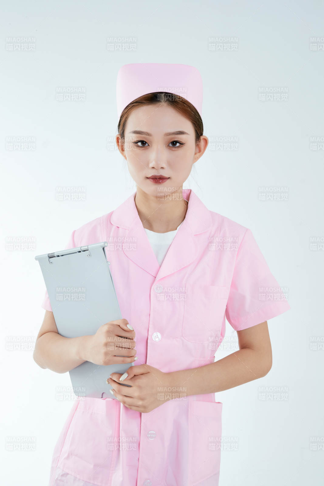 白背景里穿护士服手持病历夹的美女护士图片