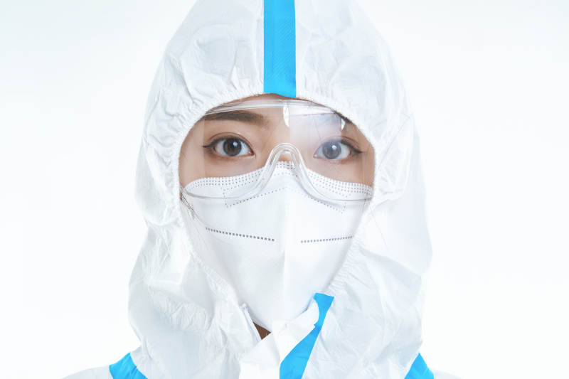 穿白色防护服佩戴护目镜口罩的女性医疗人员图片
