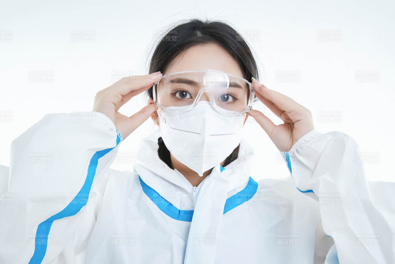穿白色防护服佩戴护目镜口罩的女性医疗人员图片