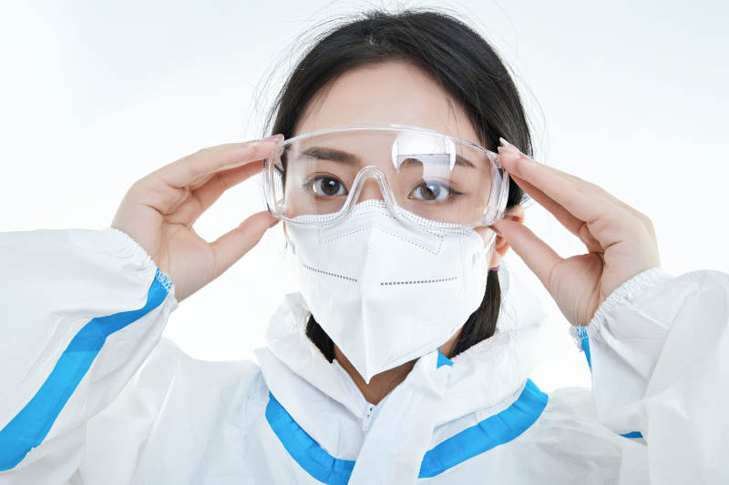 穿白色防护服佩戴护目镜口罩的女性医疗人员图片