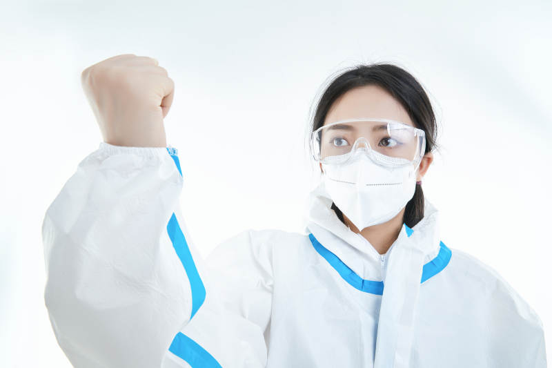 穿白色防护服佩戴护目镜口罩的女性医疗人员图片