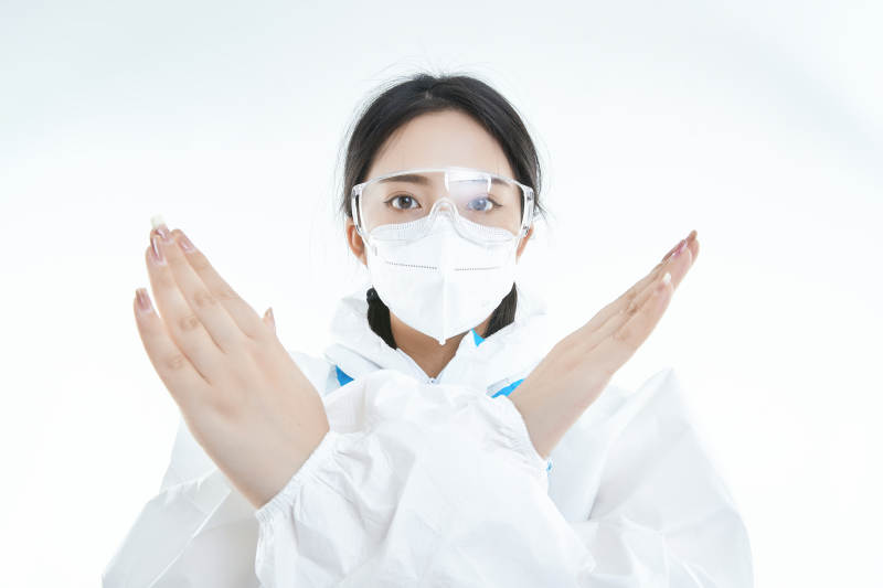 穿白色防护服佩戴护目镜口罩的女性医疗人员图片
