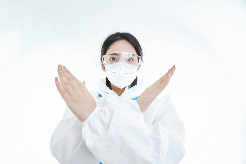 穿白色防护服佩戴护目镜口罩的女性医疗人员图片