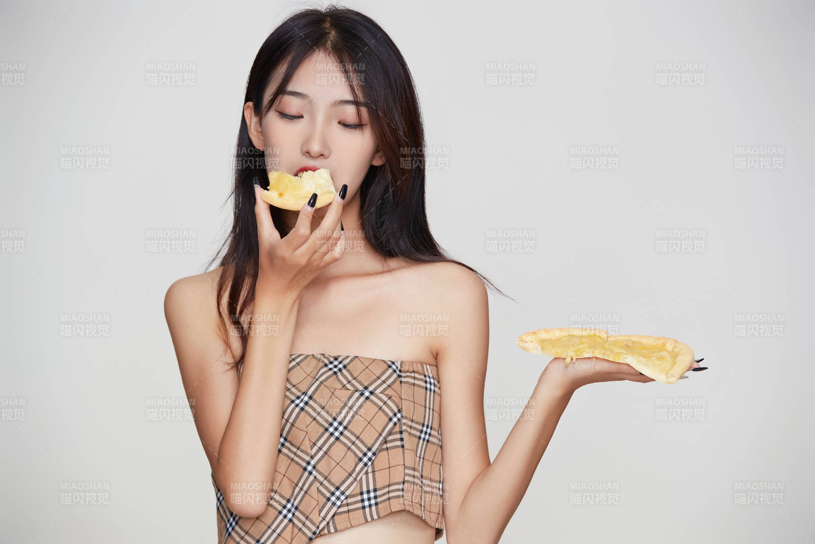 白色背景下吃着美味榴莲披萨的可爱少女图片