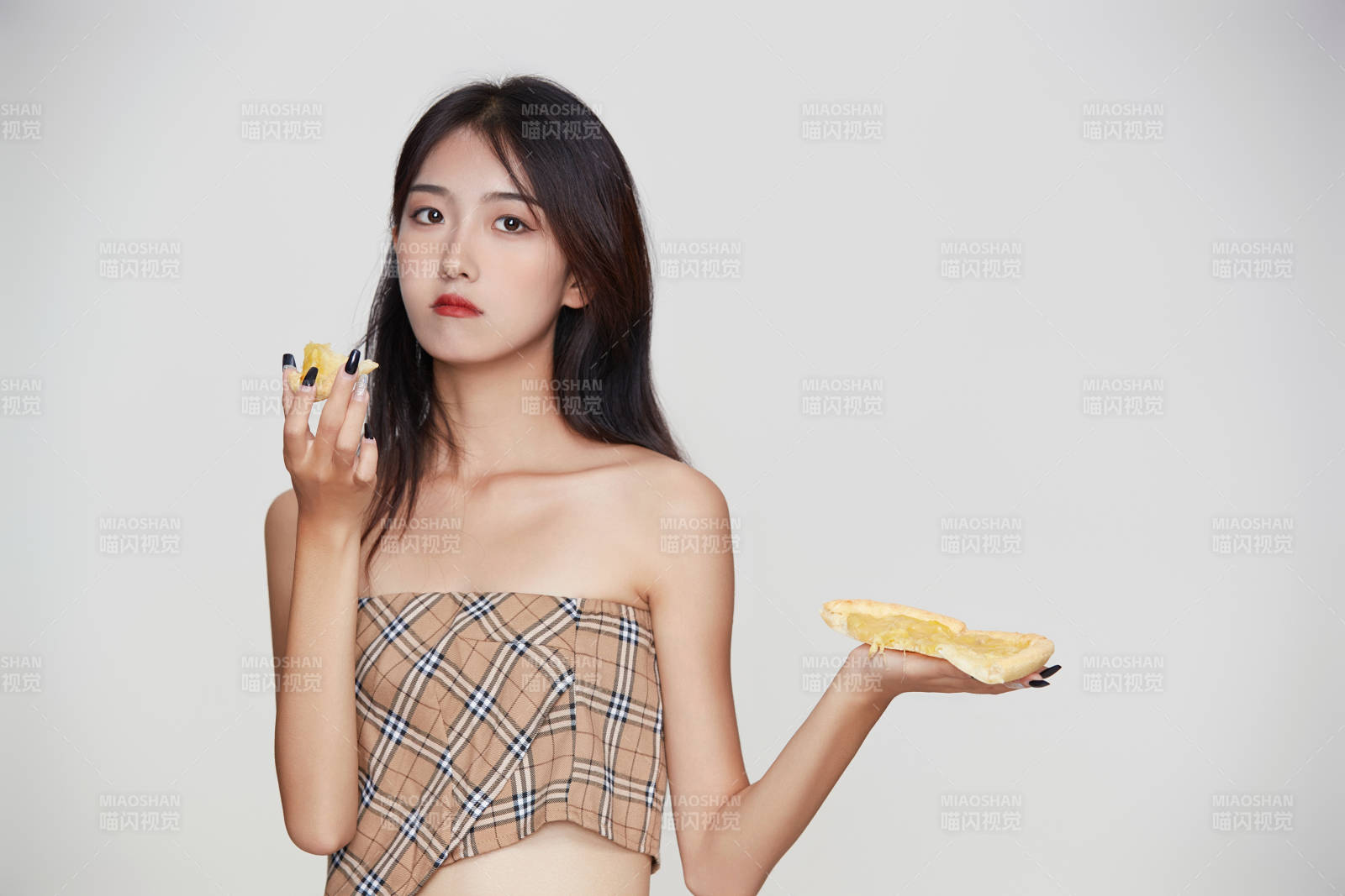 白色背景下吃着美味榴莲披萨的可爱少女图片