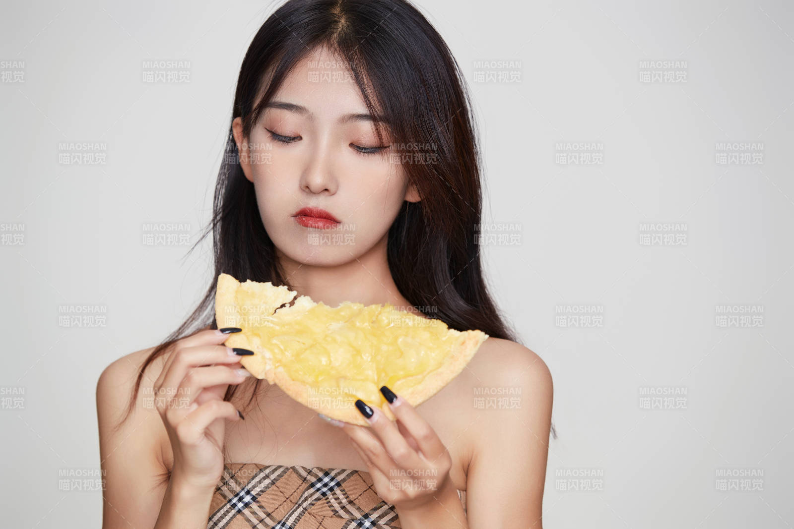 白色背景下吃着美味榴莲披萨的可爱少女图片