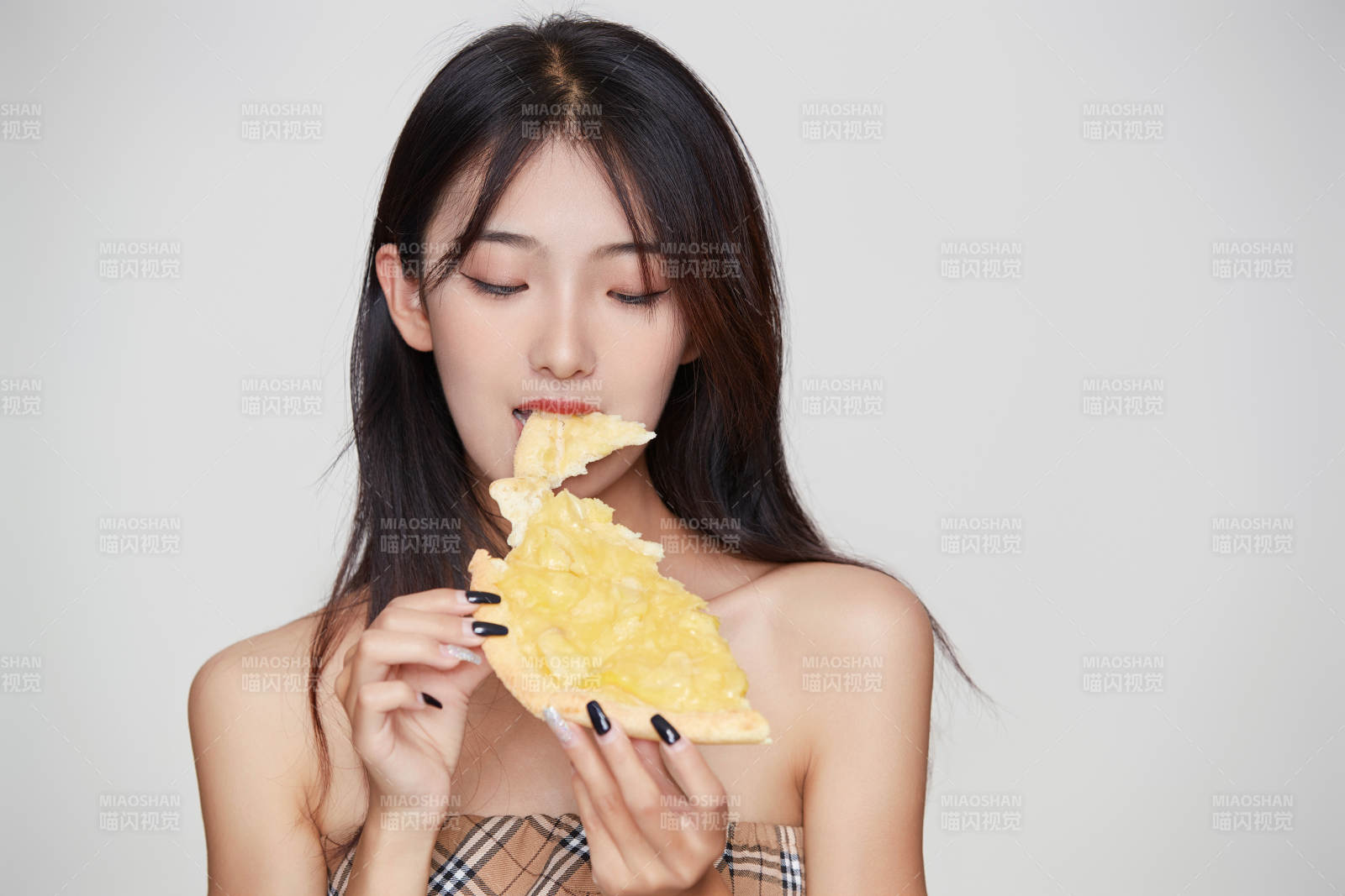 白色背景下吃着美味榴莲披萨的可爱少女图片