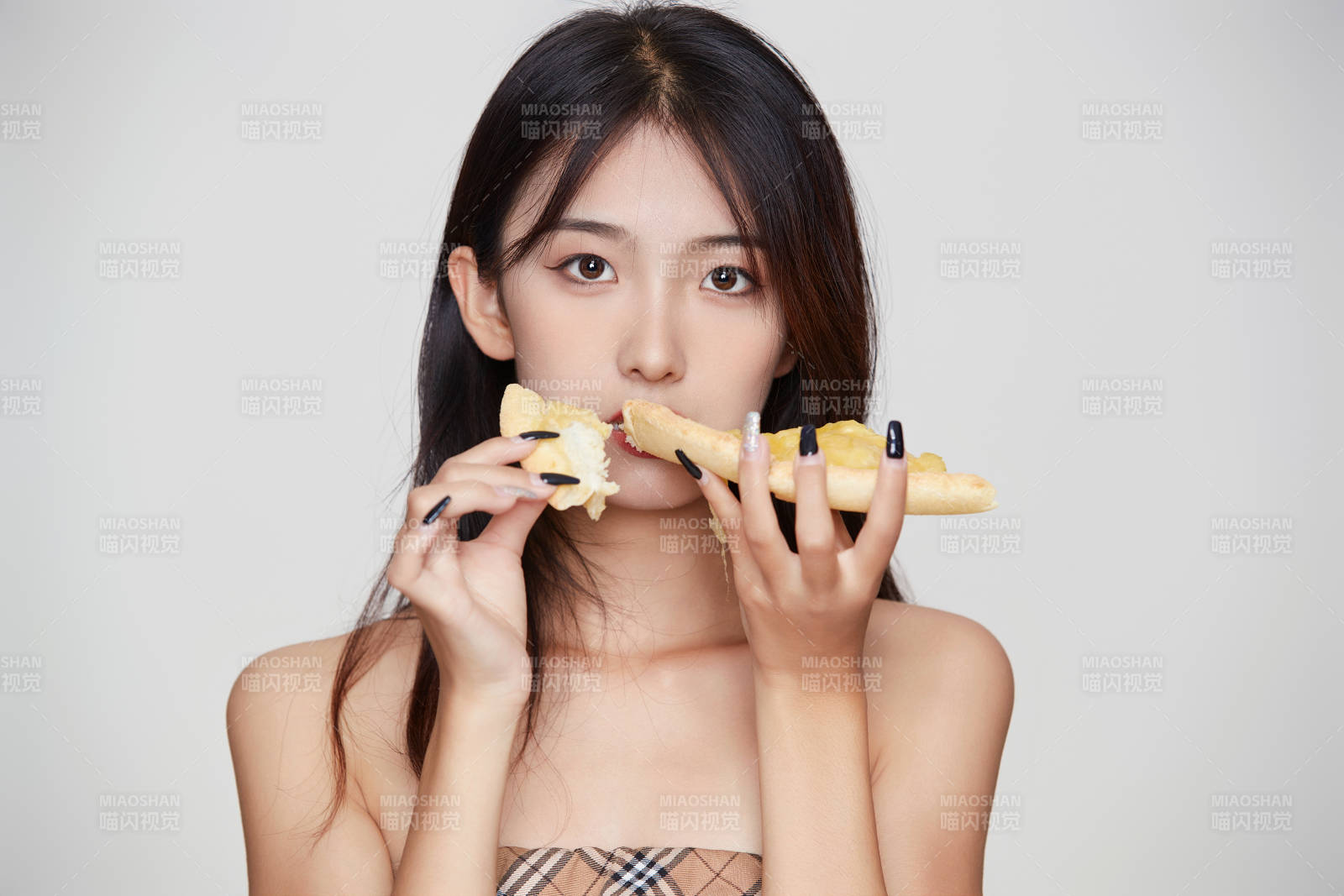 白色背景下吃着美味榴莲披萨的可爱少女图片