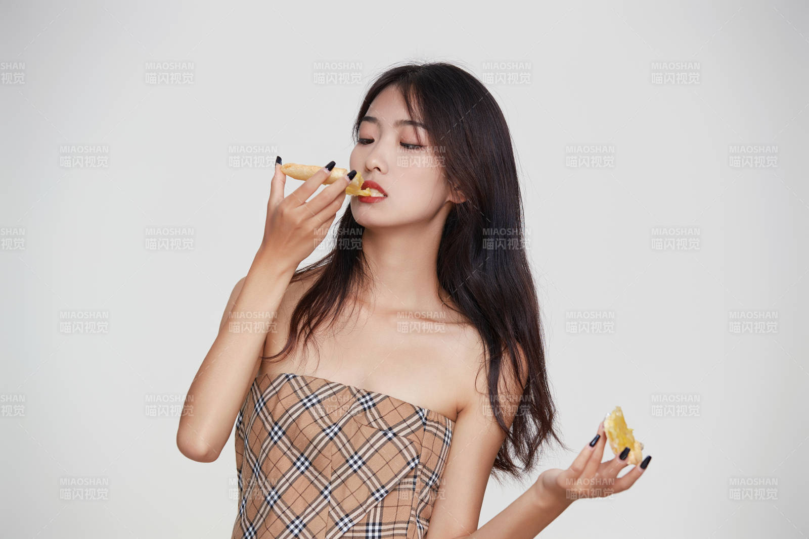 白色背景下吃着美味榴莲披萨的可爱少女图片