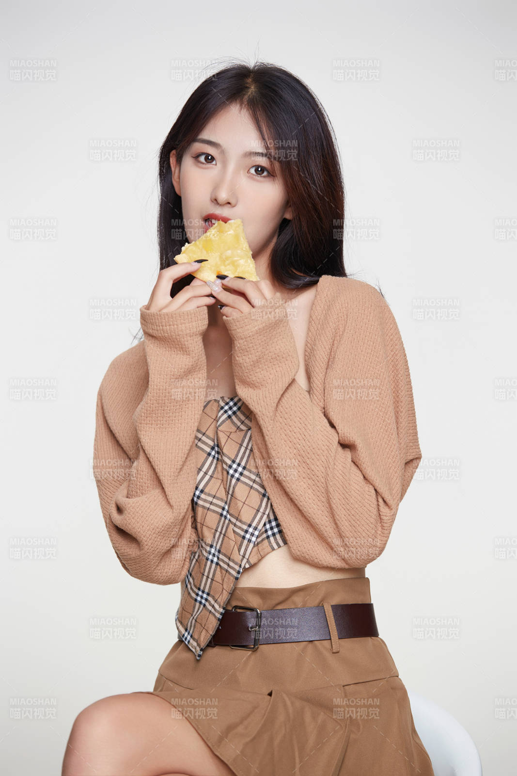 白色背景下吃着美味榴莲披萨的可爱少女图片