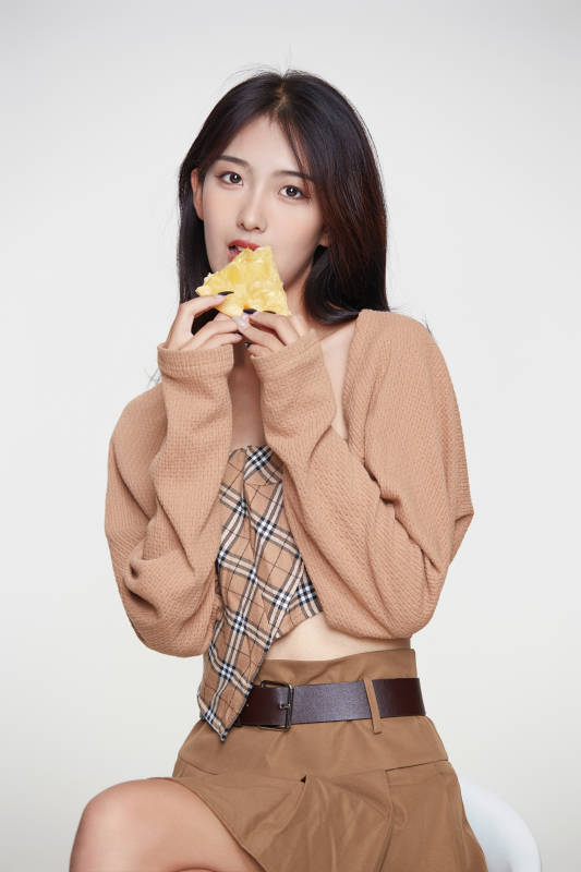 白色背景下吃着美味榴莲披萨的可爱少女图片