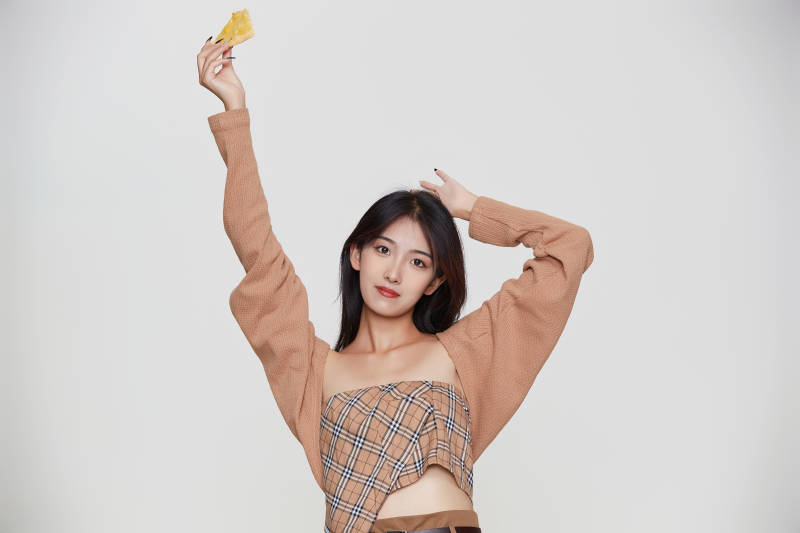 白色背景下吃着美味榴莲披萨的可爱少女图片