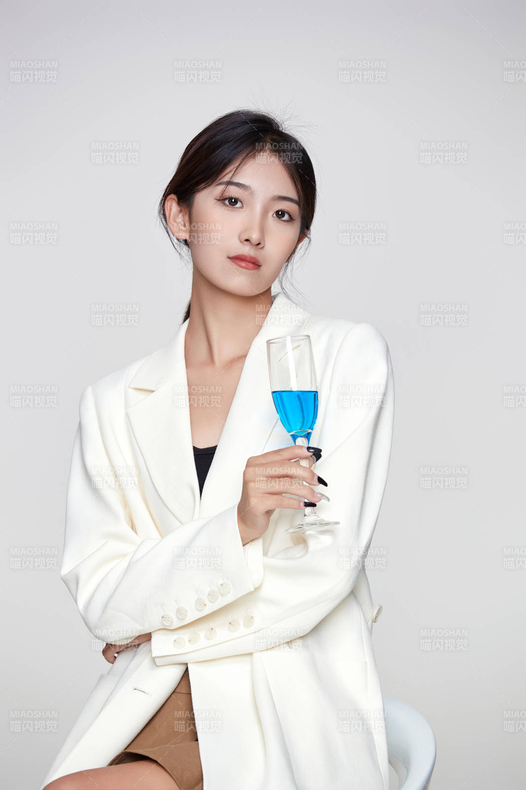 坐在椅子上手端酒杯的亚洲商务女性图片