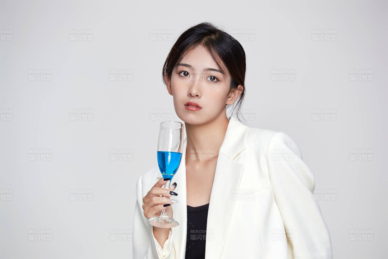 坐在椅子上手端酒杯的亚洲商务女性图片