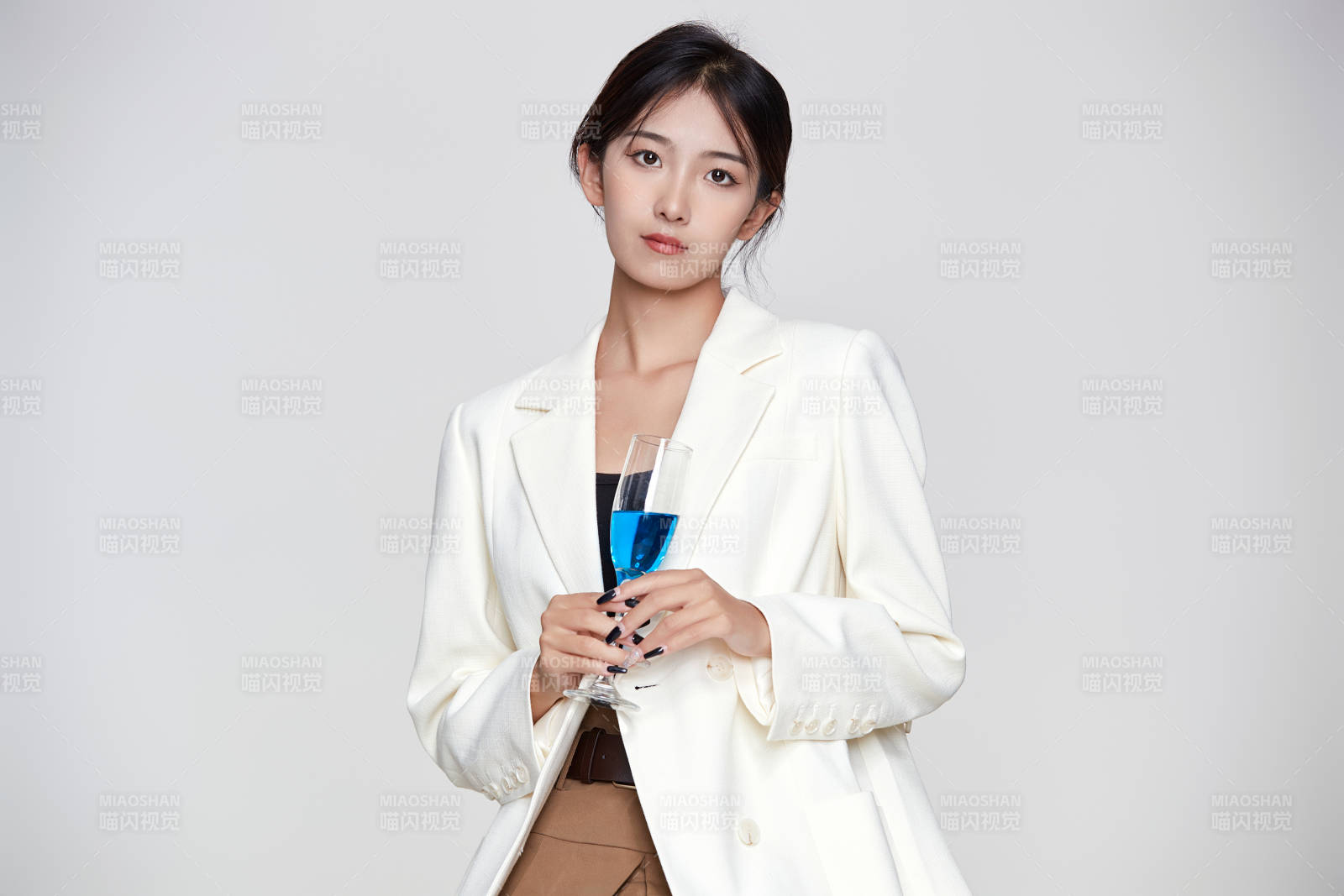 坐在椅子上手端酒杯的亚洲商务女性图片