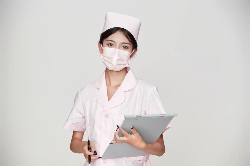 身穿粉色护士服佩戴听诊器的女性医护人员图片