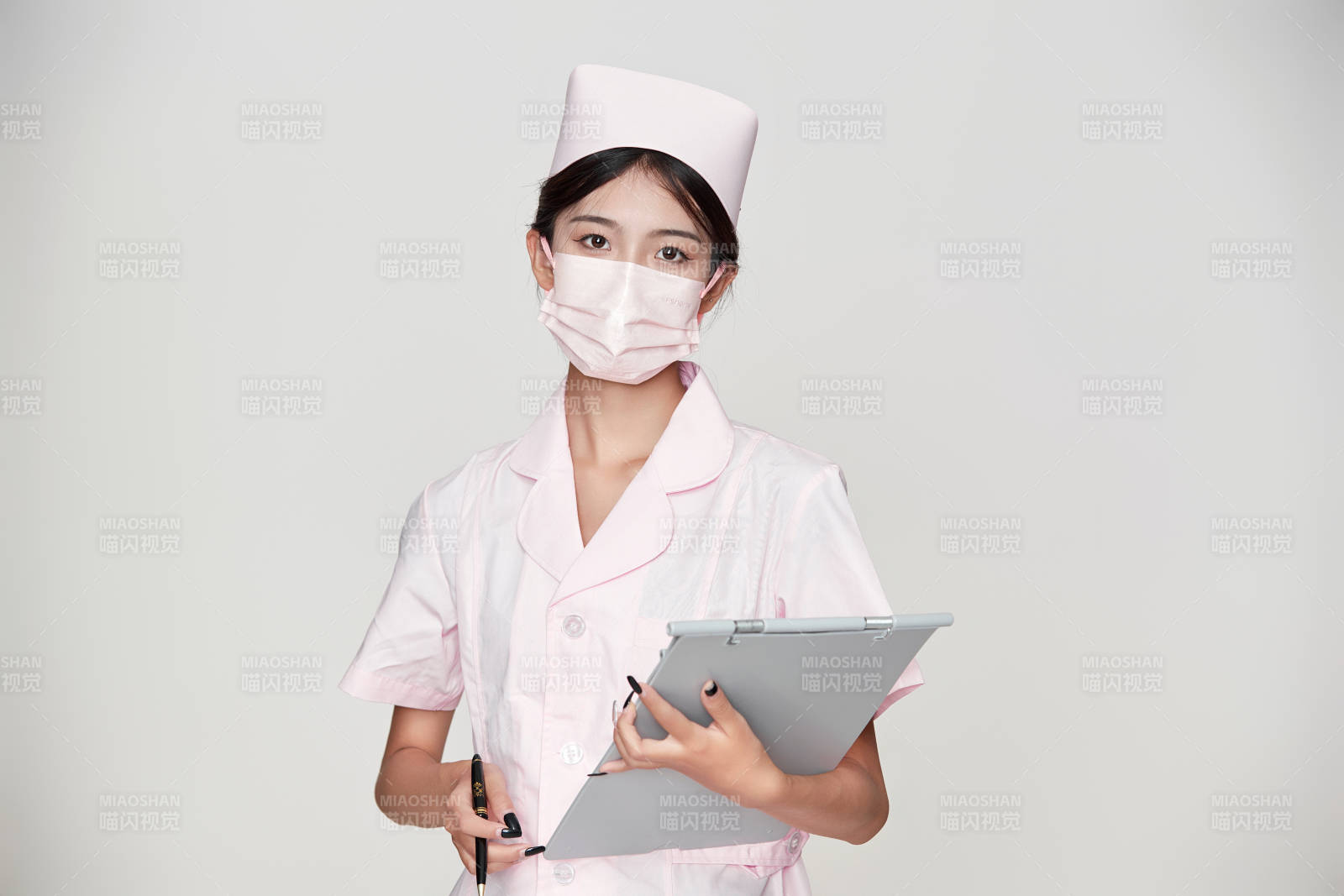 身穿粉色护士服佩戴听诊器的女性医护人员图片