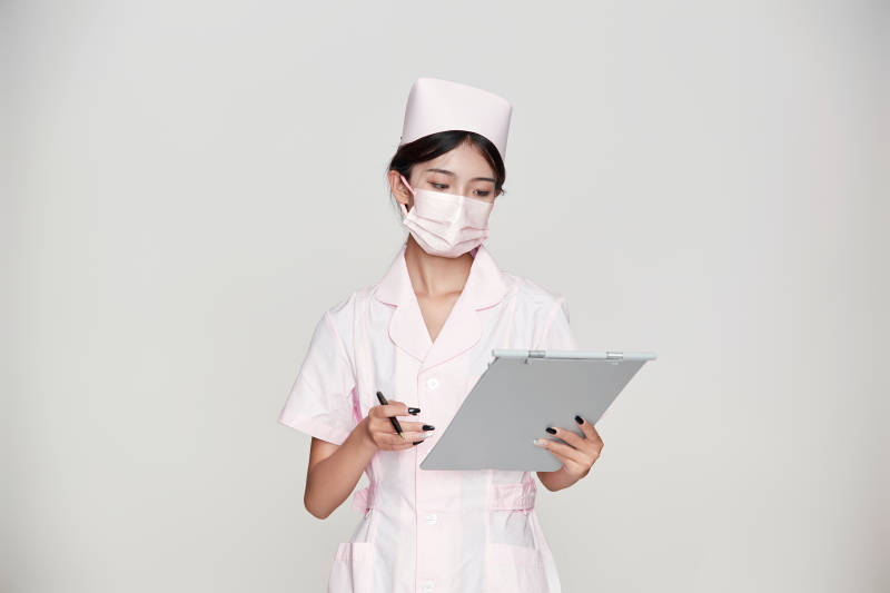 身穿粉色护士服佩戴听诊器的女性医护人员图片