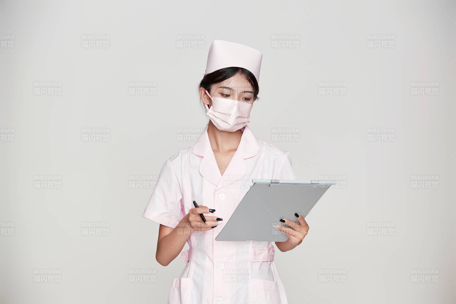 身穿粉色护士服佩戴听诊器的女性医护人员图片