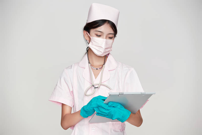 身穿粉色护士服佩戴听诊器的女性医护人员图片