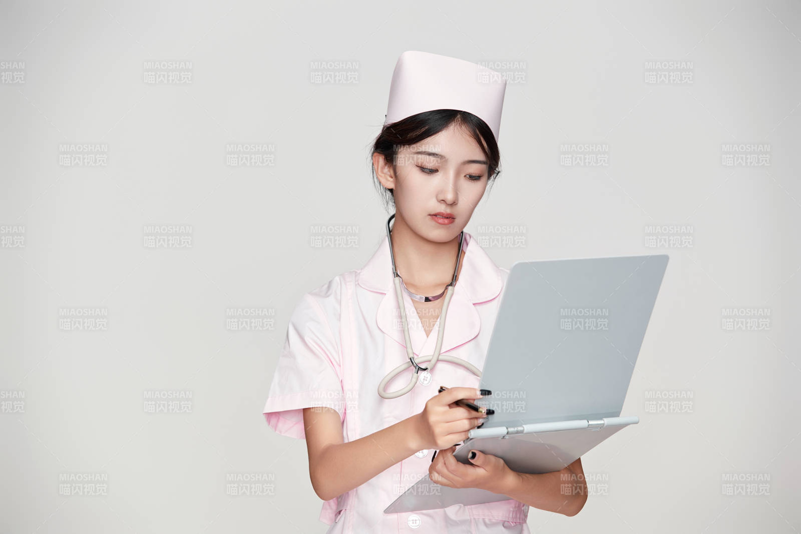 身穿粉色护士服佩戴听诊器的女性医护人员图片