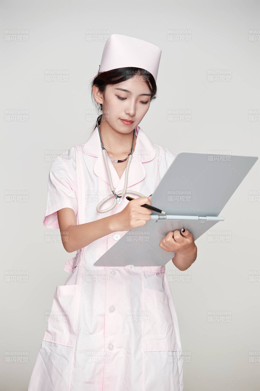 身穿粉色护士服佩戴听诊器的女性医护人员图片