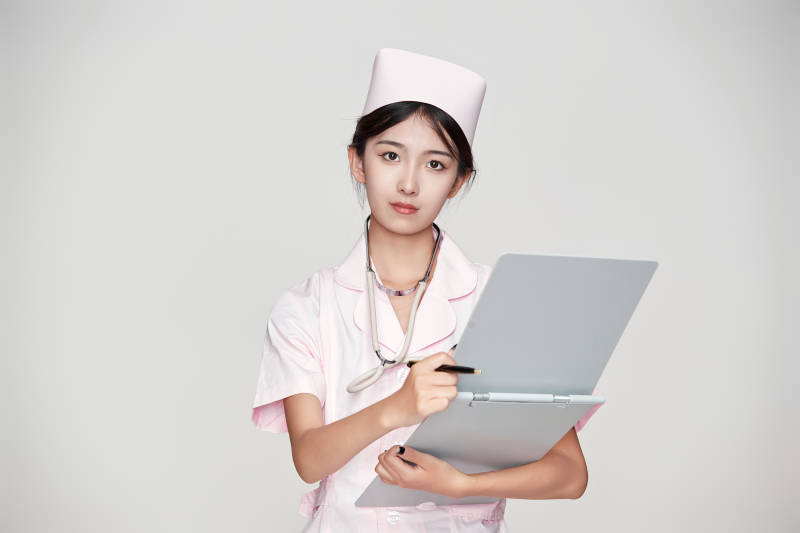 身穿粉色护士服佩戴听诊器的女性医护人员图片