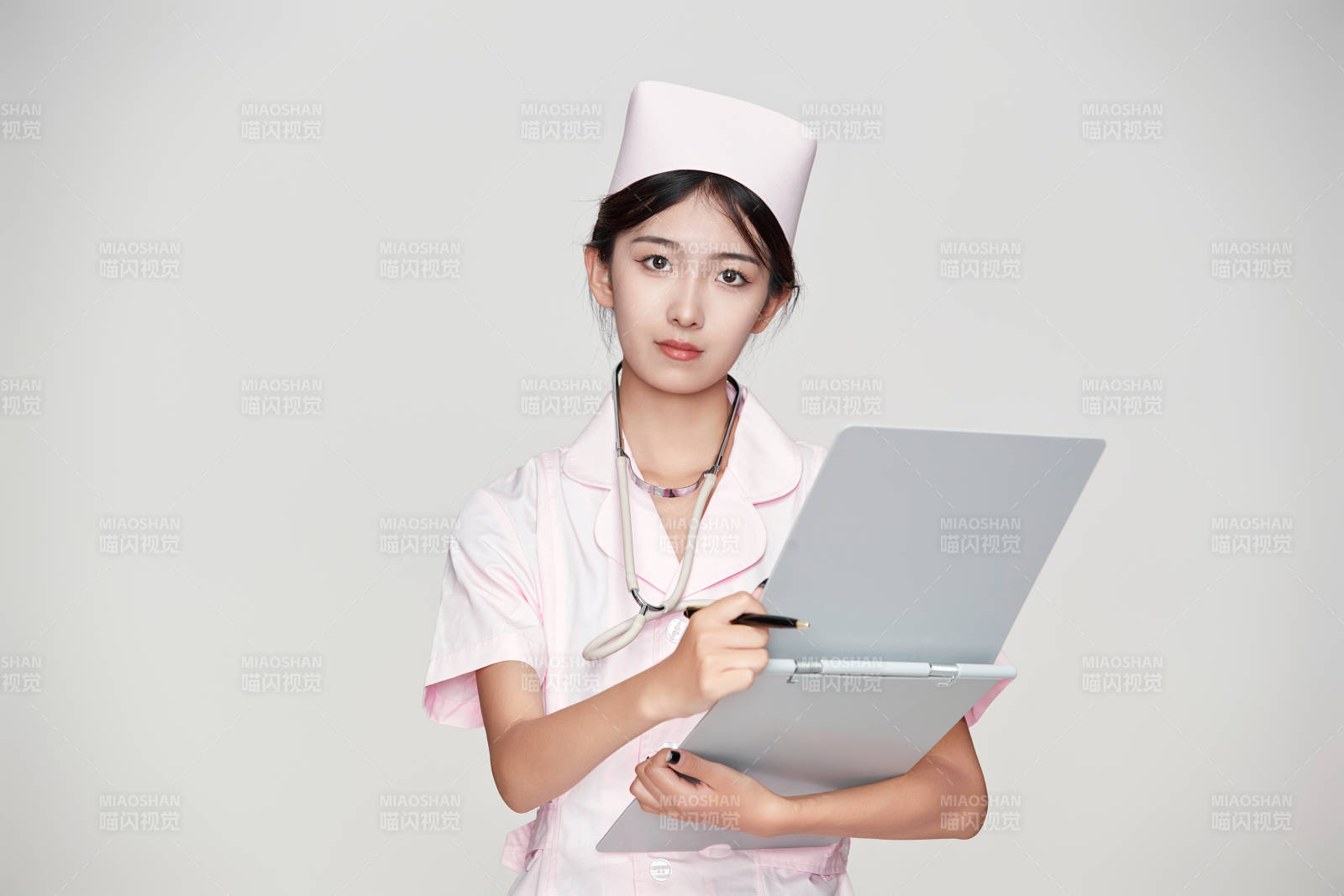 身穿粉色护士服佩戴听诊器的女性医护人员图片