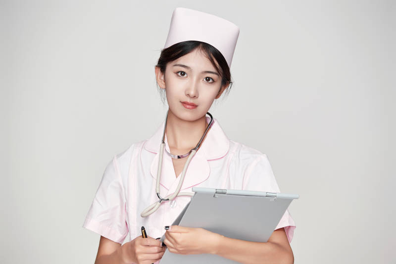 身穿粉色护士服佩戴听诊器的女性医护人员图片