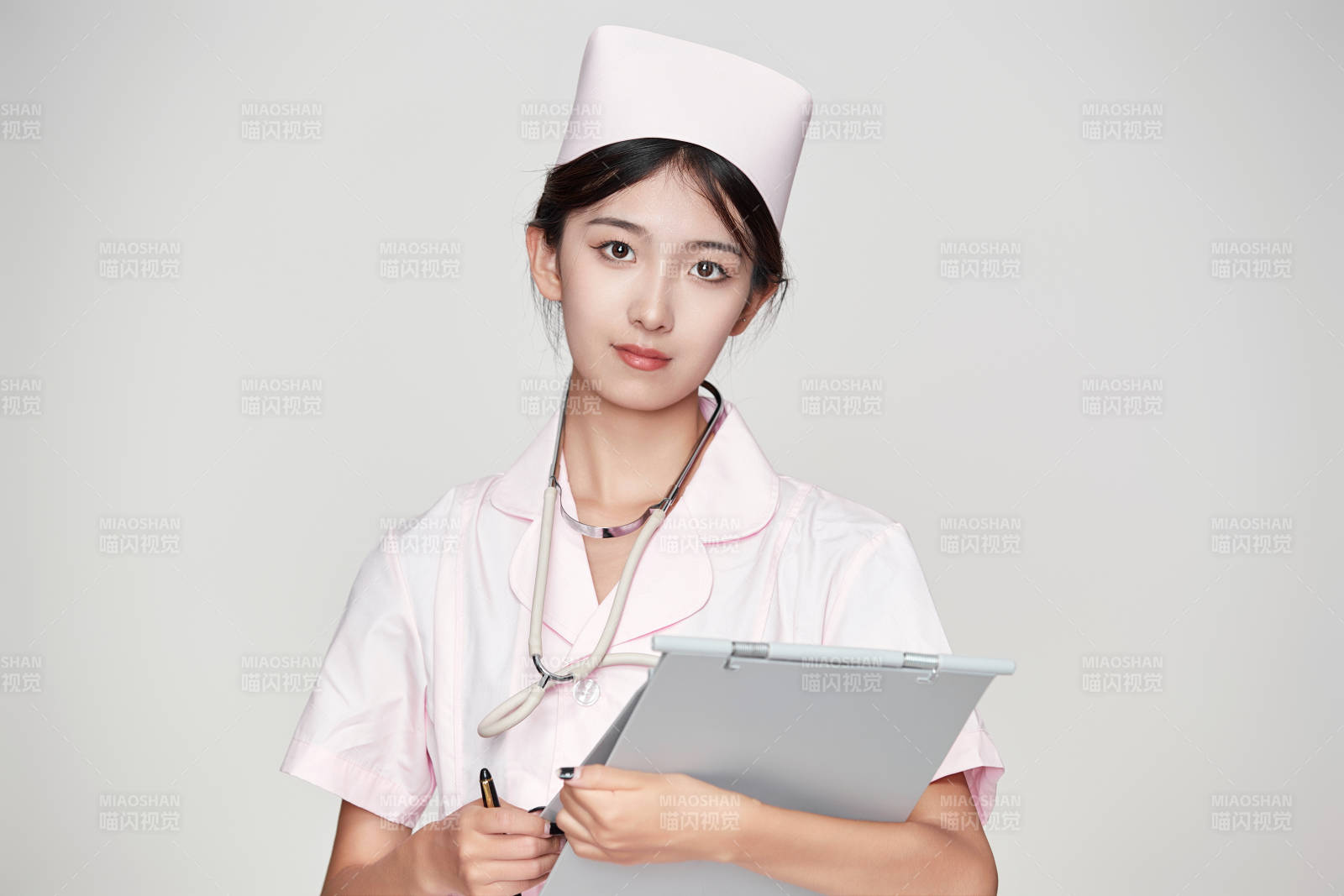 身穿粉色护士服佩戴听诊器的女性医护人员图片