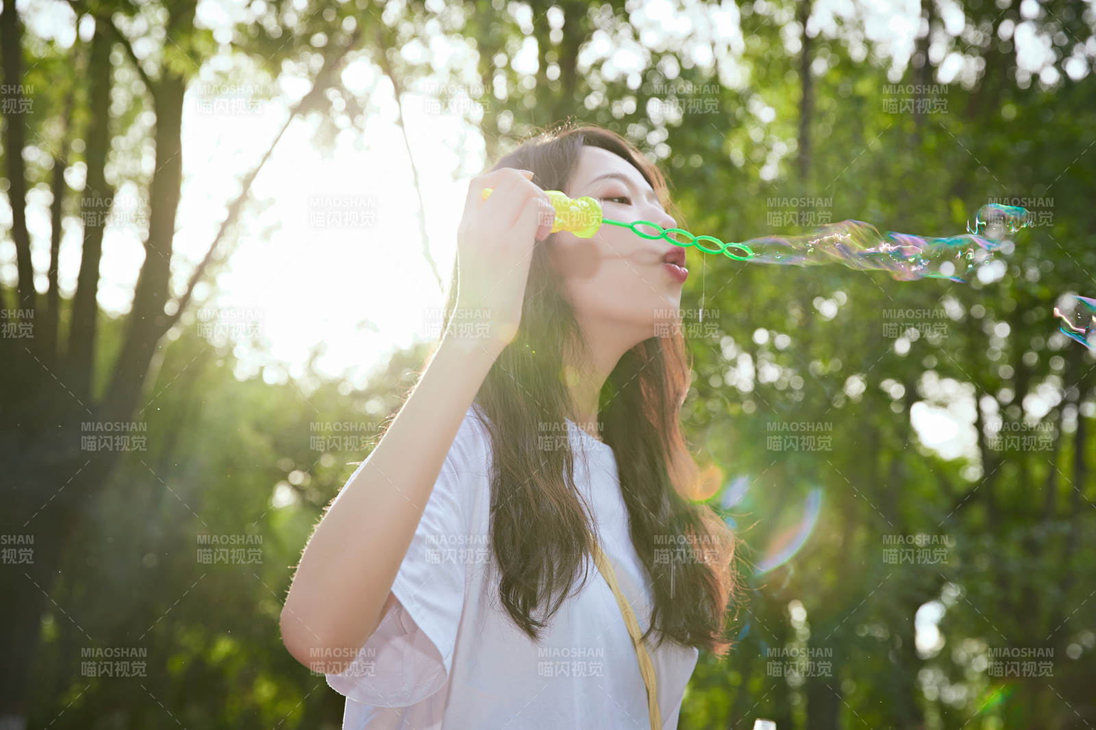 户外公园里玩吹泡泡的可爱亚洲少女图片