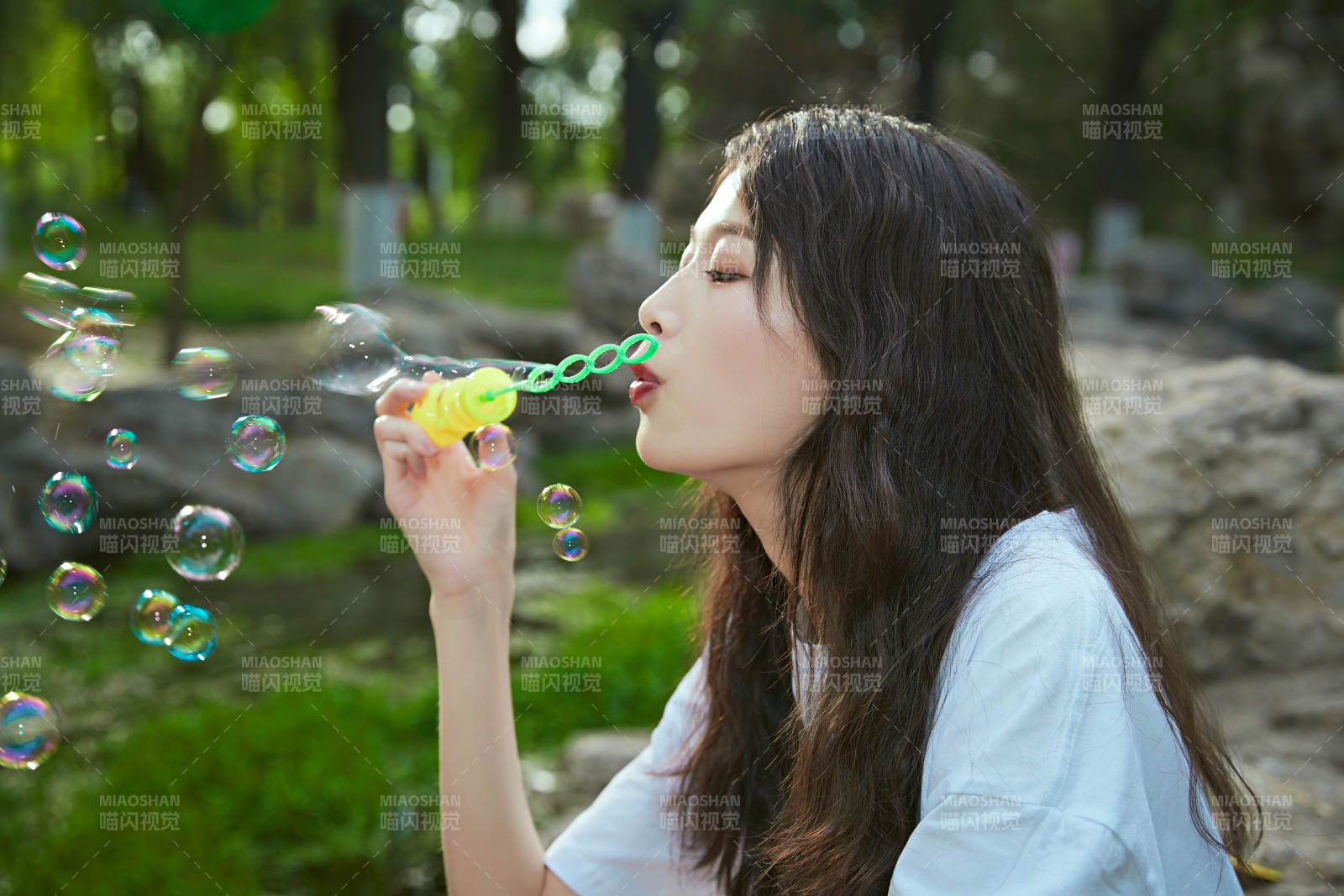 户外公园里玩吹泡泡的可爱亚洲少女图片