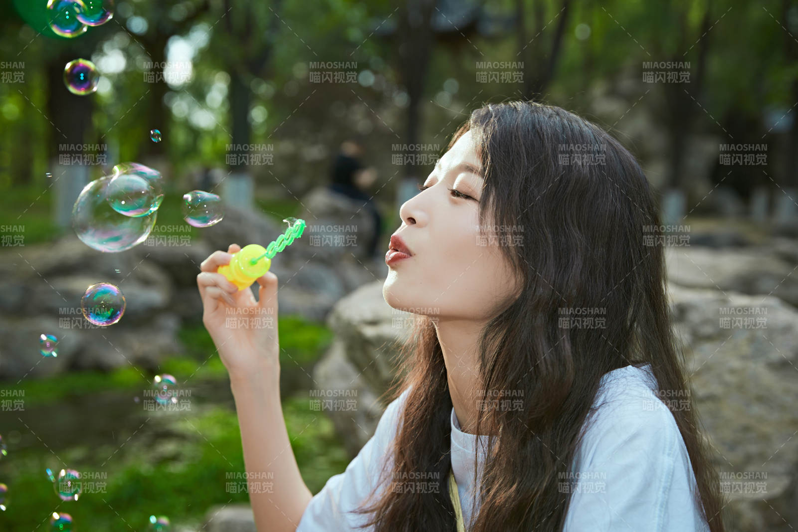 户外公园里玩吹泡泡的可爱亚洲少女图片