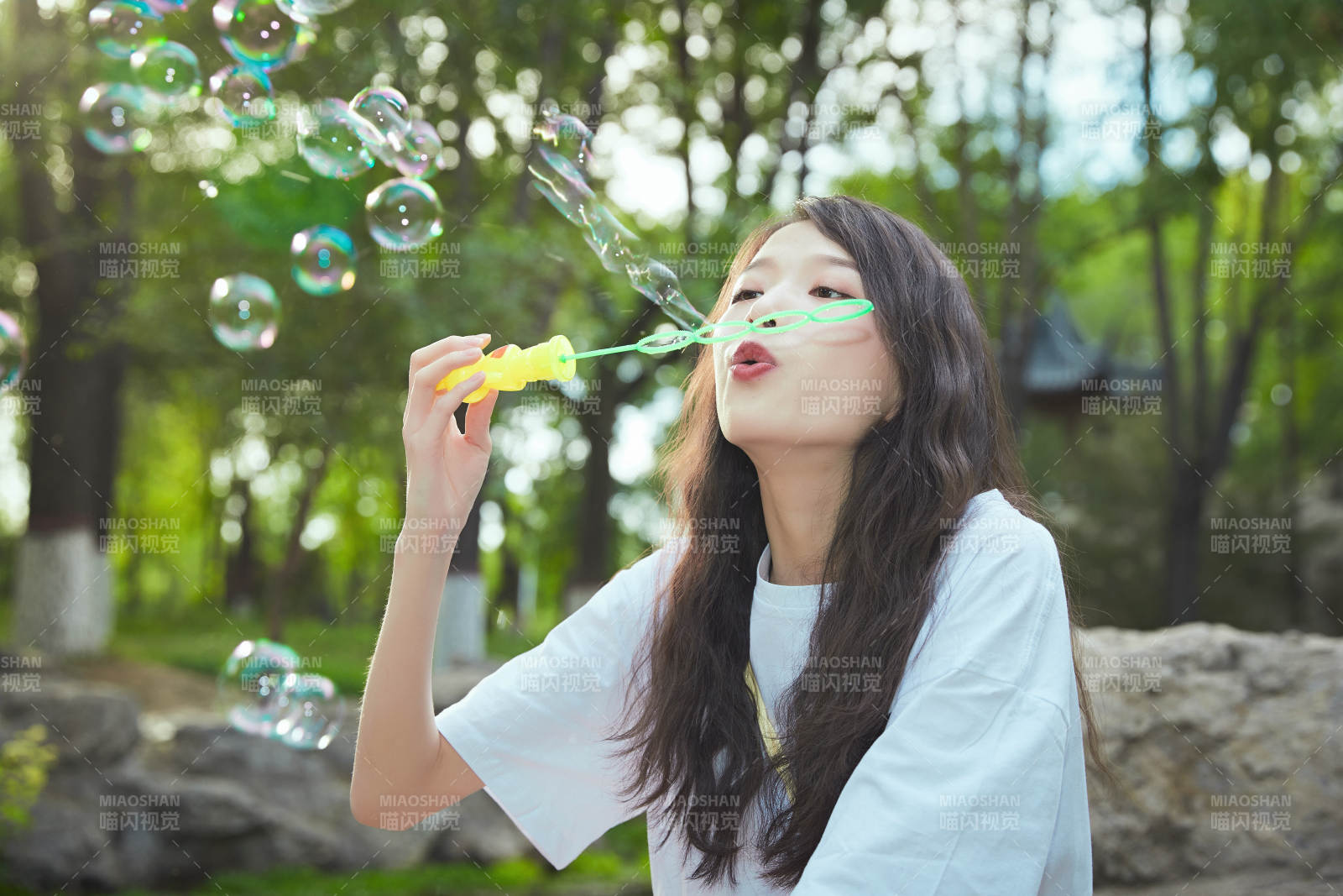 户外公园里玩吹泡泡的可爱亚洲少女图片