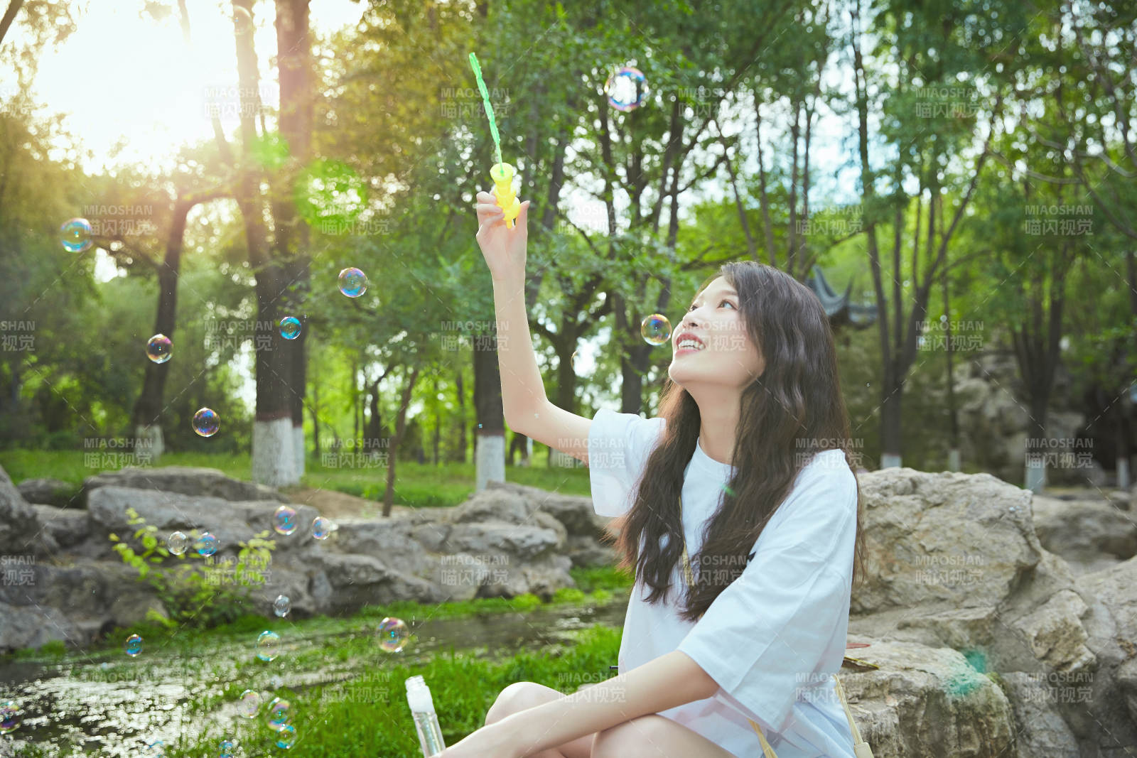 户外公园里玩吹泡泡的可爱亚洲少女图片